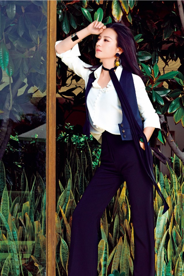 赵薇西装写真展露飒爽英姿 赵薇单手插袋立于暗色背景前,西装外套随意敞开,散发随性不羁的强者风范