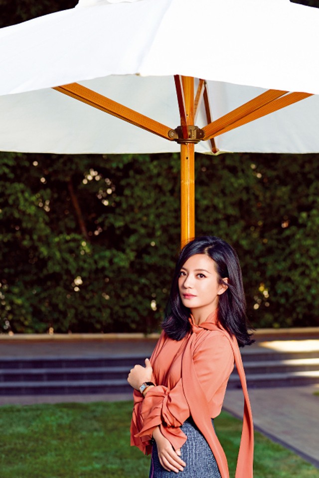 赵薇西装写真展露飒爽英姿 赵薇双手交叠神情专注,背景光影斑驳,凸显其沉静而富有张力的内心世界